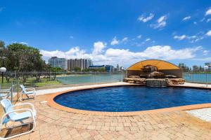 a swimming pool with a fountain and chairs around it at Bay View in Tweed Heads