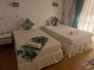 two beds in a room with palm trees on them at Villa Duran - 5 bedrooms in Ukunda