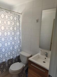 ein Badezimmer mit einem WC, einem Waschbecken und einem Spiegel in der Unterkunft Casa en Sector Oriente de Talca in Talca