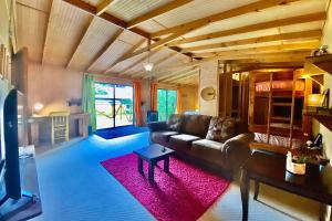 uma sala de estar com um sofá e um tapete rosa em MaPatagonia Hostel Casa Patrimonial em Puerto Varas