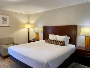una habitación de hotel con una cama grande y una silla en Rose Garden Inn, en Santa Bárbara
