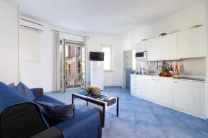 a living room with a couch and a kitchen at Cafiero Azure Flat in Sorrento