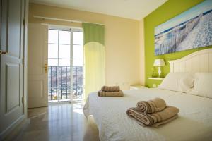 - une chambre avec un lit blanc et des serviettes dans l'établissement Orquídea Holiday Modern House, à Mogán