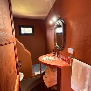 La salle de bains est pourvue d'un lavabo et d'un miroir. dans l'établissement Cabañas Taos Pueblo, à Capilla del Monte