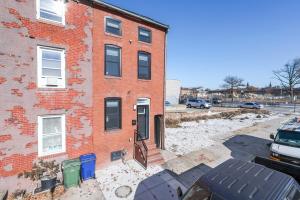 un edificio de ladrillo con una puerta en un estacionamiento en Cozy Ba Townhome Near Little Italy I Fells Point en Baltimore