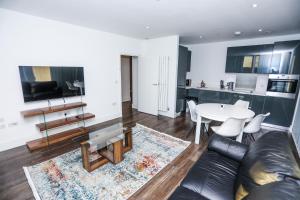 LUXURY 2 BED WOOLWICH ARSENAL Apartment في لندن: غرفة معيشة مع أريكة وطاولة