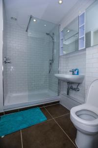 LUXURY 2 BED WOOLWICH ARSENAL Apartment في لندن: حمام مع دش ومرحاض ومغسلة