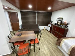 una habitación con mesa y sillas y un dormitorio en Bello apartamento en Baños de Agua Santa, en Baños