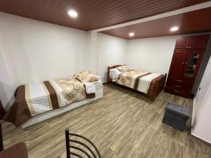 Habitación con 2 camas y suelo de madera. en Bello apartamento en Baños de Agua Santa, en Baños