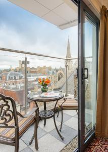 a balcony with a table and a view of a city at The George Street Hotel in Oxford