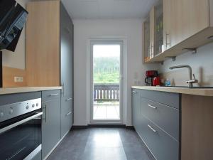 a kitchen with a sink and a window in it at Detached holiday home in Deifeld with balcony, covered terrace and garden in Medebach