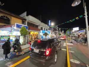 un coche conduciendo por una calle de la ciudad por la noche en Bello apartamento en Baños de Agua Santa, en Baños