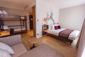 ein Schlafzimmer mit einem Bett und einem Etagenbett in der Unterkunft Hotel Libertas elements pure in Freiburg im Breisgau