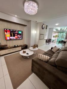 a living room with a couch and a tv at Excelente Apartamento Alto Padrão Centro Ed Dubai in Capão da Canoa