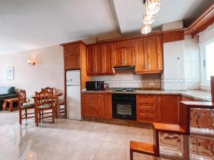 プラヤ・デ・ラス・アメリカスにあるLos Agaves Apartment with ocean view LA116のキッチン(木製キャビネット、テーブル、椅子付)