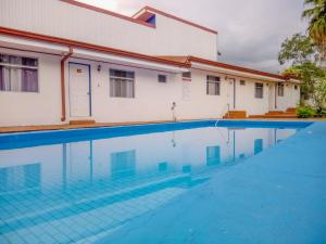 a swimming pool in front of a building at Hotel Geliwa in Turrialba