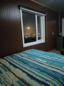 プンタ・アレナスにあるcabaña ateneaのベッドと景色の見える窓のある寝室