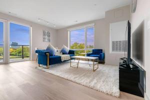 un salon avec un canapé bleu et une télévision dans l'établissement Luxurious&modern with balcony on the charles River, à Boston