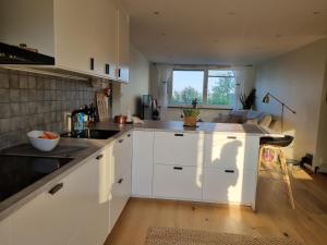 a kitchen with white cabinets and a large window at Welcoming single room in the city center in Gothenburg