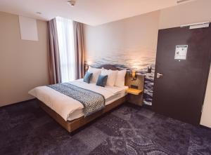 ein Hotelzimmer mit einem Bett in einem Zimmer in der Unterkunft Hotel Libertas elements pure in Freiburg im Breisgau