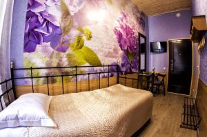 a bedroom with a bed with a flower mural on the wall at Bonjour Hotel in Saint Petersburg