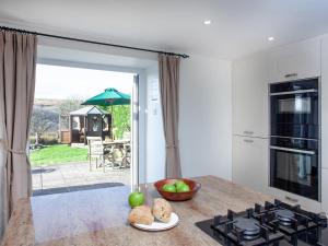 a kitchen with a table with a bowl of fruit on a counter at Dunstone Cottage in Shaugh Prior