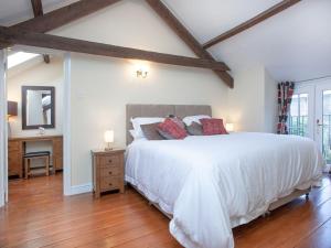 a bedroom with a large white bed and a wooden floor at Dunstone Cottage in Shaugh Prior