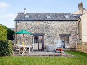 a house with a table and an umbrella in the yard at Dunstone Cottage in Shaugh Prior