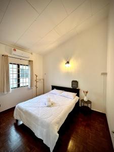 ein Schlafzimmer mit einem großen weißen Bett in einem Zimmer in der Unterkunft Ipoh Deluxe Family Home in Ipoh