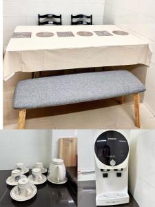 une table avec un banc et une machine à café dans l'établissement Ipoh Deluxe Family Home, à Ipoh