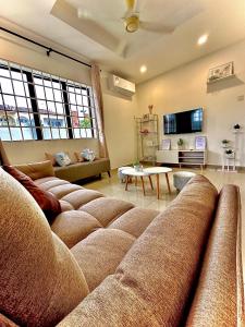 a living room with a large couch and a table at Ipoh Deluxe Family Home in Ipoh