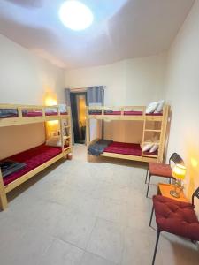 a room with three bunk beds and a couch at Backpackers zone in Dubai