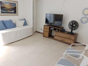 sala de estar con sofá blanco y TV en Praia Grande- Villa da Praia - Cobertura Duplex!, en Arraial do Cabo