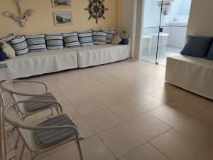 sala de estar con sofá y silla en Praia Grande- Villa da Praia - Cobertura Duplex!, en Arraial do Cabo
