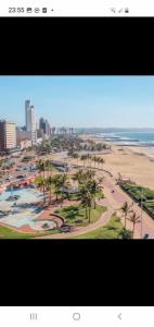 a view of a beach with palm trees and the ocean at Durban Beachfront OceanSeaside Self Catering Apartments in Durban
