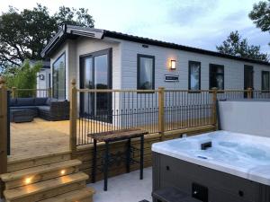 a tiny house with a hot tub on a deck at Peacock - Uk31513 in Calthwaite
