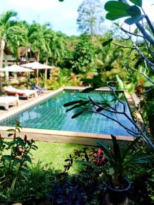 a swimming pool in the middle of a garden at Privacy Resort - Koh Chang in Ko Chang