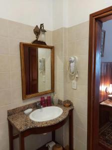 uma casa de banho com um lavatório e um espelho em La Cara Oculta de Salta, bed and breakfast em Salta