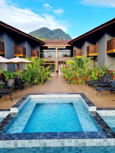 a swimming pool in front of a building with a resort at Pousada Vila Ipuan in Pauba