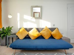 キングスブリッジにあるWaterside Park Annexeの青いソファ(黄色の枕付)が備わるリビングルーム
