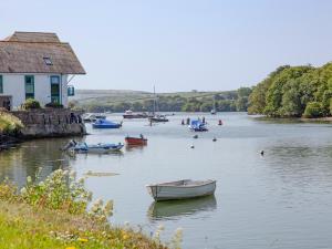 a group of boats on a river with a house at Waterside Park Annexe in Kingsbridge