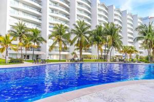 a large swimming pool in front of a building at 8th Floor Villa Magna Condo in Nuevo Vallarta