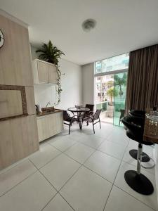 Excelente Apartamento Alto Padrão Centro Ed Dubai في كاباو دا كانوا: مطبخ وغرفة معيشة مع طاولة وكراسي