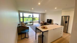 a kitchen and living room with a counter and a table at Tahuna Beach Apartment in Nelson