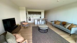 a living room with a couch and a tv at Tahuna Beach Apartment in Nelson