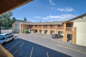 ein großes Gebäude mit Autos auf einem Parkplatz in der Unterkunft Moose Creek Lodge & Suites in Cody