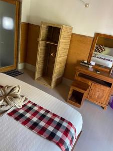 a bedroom with a bed with a mirror and a dresser at Grealeen Cottages in Nusa Penida