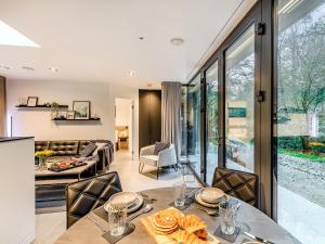 a kitchen and living room with a table and chairs at The Pump House Lodge in Elslack