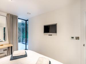 a bedroom with a bed and a tv on a wall at The Pump House Lodge in Elslack