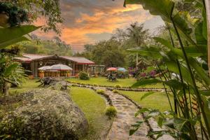 un jardín con un camino de piedra que conduce a un edificio en Ecohotel Piedemonte en Salento